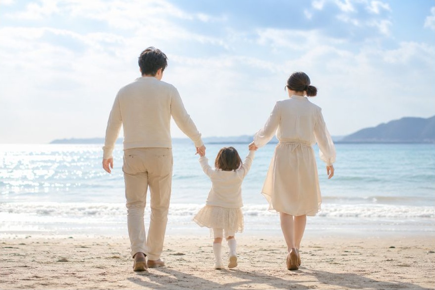 海辺を歩く家族