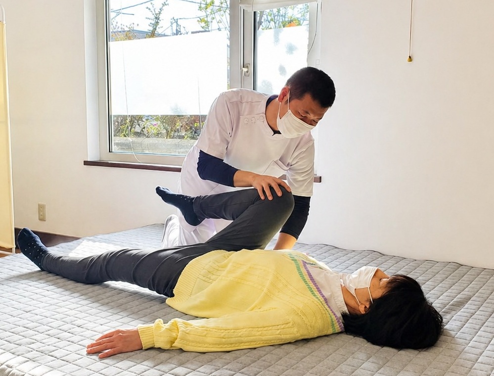 ベッドで横になった女性の脚を施術している様子